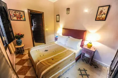 a bedroom with a large bed and a night stand with a nightstand at Riad Errabii & Spa in Marrakech