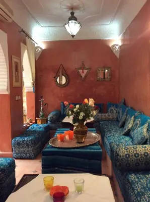 a living room with blue couches and a table at Riad Aquarelle By GE in Marrakech