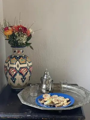 a plate of food on a table with a vase at HOTEL EL AMAL in Marrakech