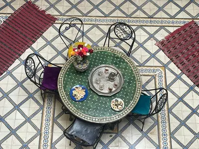 a green table with flowers on top of a table at HOTEL EL AMAL in Marrakech