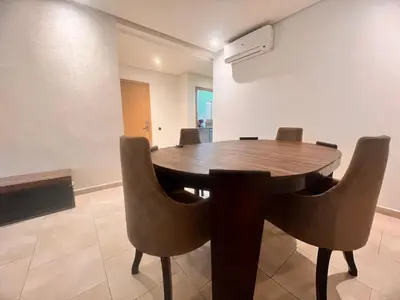 a dining room with a wooden table and chairs at Opale CITY GOLF Luxe Apart 3 Rooms in Marrakech