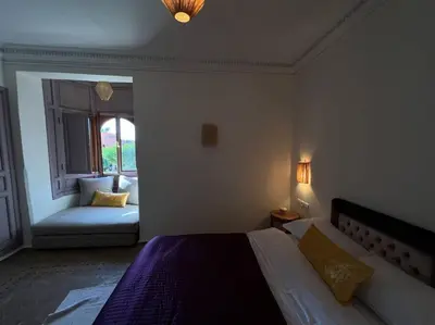 a bedroom with a bed and a window with a couch at Villa 1 by Majestic Properties in Marrakech