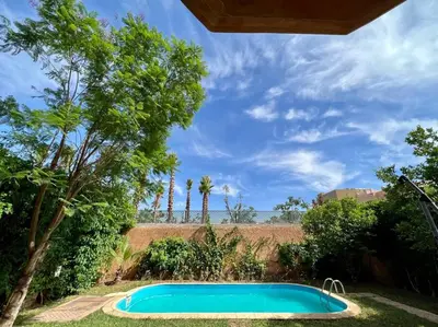 a swimming pool in a yard with palm trees at Villa 1 by Majestic Properties in Marrakech