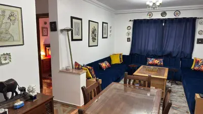 a living room with a blue couch and a table at شقة الفن Art Apartment in Marrakech