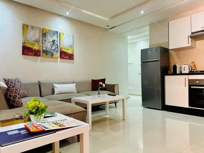 a living room with a couch and a kitchen at Chic & Lovely Flat in City Center in Marrakech