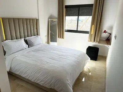 a bedroom with a white bed and a window at Appartement Marrakech luxe in Marrakech