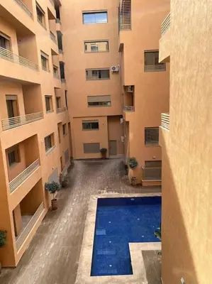 an empty courtyard of a building with a swimming pool at App centre-ville in Marrakech