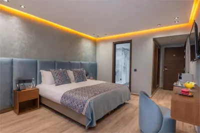 a bedroom with a king sized bed and a desk at Swiss Continental Hôtel in Marrakech