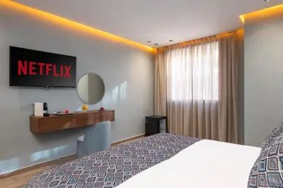 a hotel room with a bed and a mirror at Swiss Continental Hôtel in Marrakech