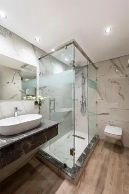 a bathroom with a glass shower and a sink at Swiss Continental Hôtel in Marrakech