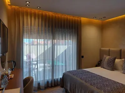 a bedroom with a bed and a large window at Swiss Continental Hôtel in Marrakech