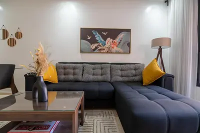 a living room with a blue couch and a table at Royal KING Bed SUITE W/POOL in Marrakech