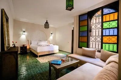 a bedroom with a bed and a stained glass window at Riad Zazz in Marrakech