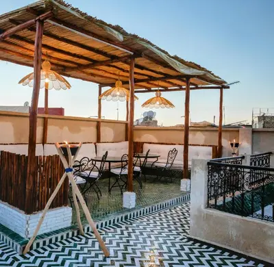 a patio with tables and chairs under a pavilion at Riad Zazz in Marrakech