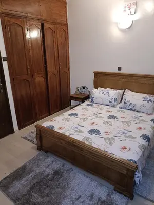 a bedroom with a bed and a wooden cabinet at 1 Room only for women للنساء فقط in Marrakech