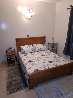 a bedroom with a bed with a wooden headboard and pillows at 1 Room only for women للنساء فقط in Marrakech