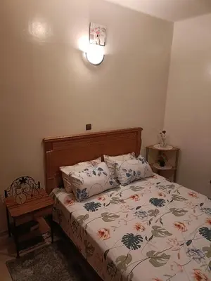 a bedroom with a bed with a floral bedspread at 1 Room only for women للنساء فقط in Marrakech