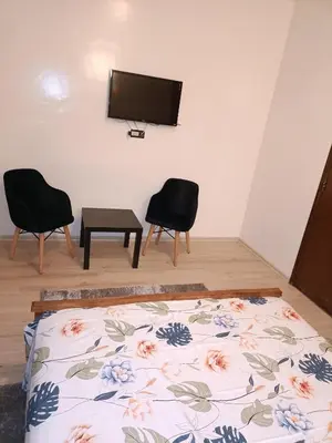 a bedroom with two chairs and a tv on the wall at 1 Room only for women للنساء فقط in Marrakech
