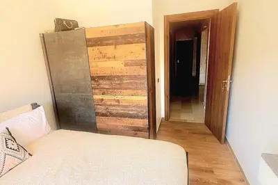 a room with a wooden door and a couch and a doorway at appartement chic haut standing centre gare in Marrakech
