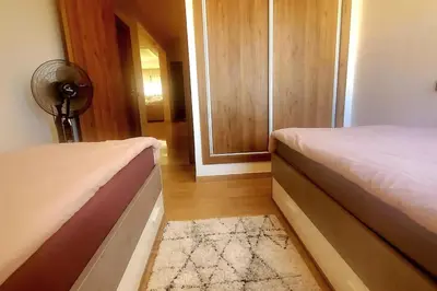 a bedroom with two beds and a fan and a door at appartement chic haut standing centre gare in Marrakech