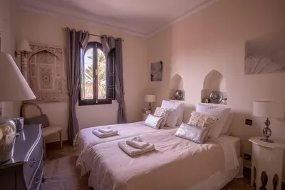 a bedroom with a bed with two towels on it at Dar Ines - Palmeraie, 250m2, pool, patio, terrace in Marrakech