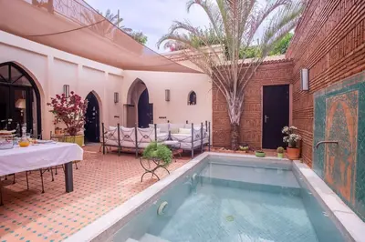 a house with a swimming pool with a table and chairs at Dar Ines - Palmeraie, 250m2, pool, patio, terrace in Marrakech