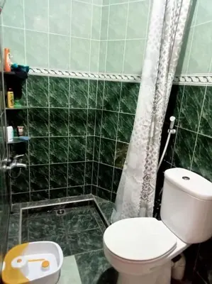 a green tiled bathroom with a toilet and a shower at Nahe Park Issil und Marjane. Yoga auf Anfrage. in Marrakech