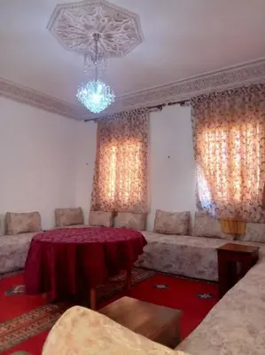 a living room with a table and a couch at Nahe Park Issil und Marjane. Yoga auf Anfrage. in Marrakech