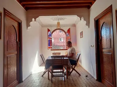 a man sitting at a table in a room at Nahe Park Issil und Marjane. Yoga auf Anfrage. in Marrakech