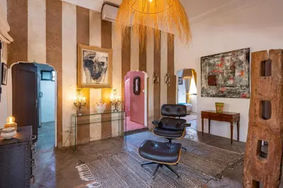 a living room with a chair and a wall with stripes at Private Villa Comfort & Relax-Heated Pool in Marrakech