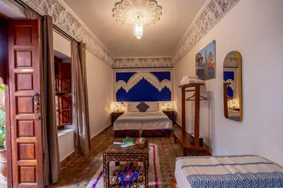 a bedroom with a bed and a chandelier at Riad Amalia in Marrakech