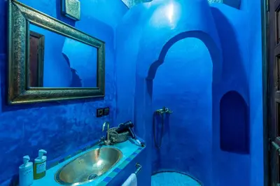 a blue bathroom with a sink and a mirror at Riad Amalia in Marrakech