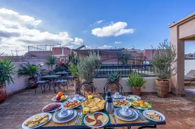 a table with plates of food on a patio at Riad Amalia in Marrakech