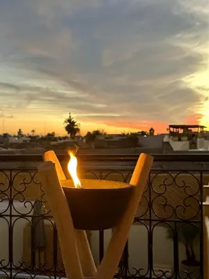 a chair sitting on a balcony with a candle at Riad le R - Riad privatif de luxe in Marrakech