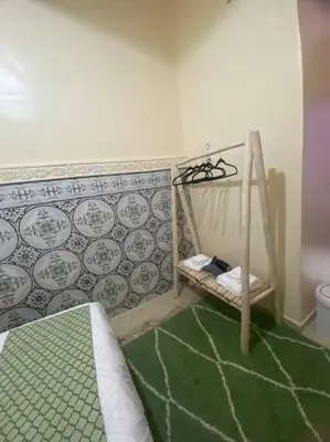 a small bedroom with a bed and a green rug at Medina House in Marrakech