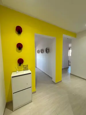 a room with a yellow wall and a white cabinet at Musée YSL Cozy, Familial, Chic in Marrakech