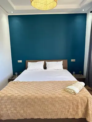 a bedroom with a bed with a blue wall at Musée YSL Cozy, Familial, Chic in Marrakech