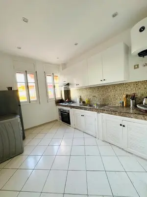a kitchen with white cabinets and a tile floor at Musée YSL Cozy, Familial, Chic in Marrakech