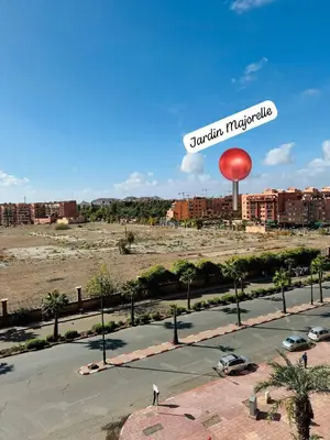 a person standing in a parking lot with a water tower at Musée YSL Cozy, Familial, Chic in Marrakech