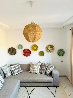 a living room with a couch and plates on the wall at Musée YSL Cozy, Familial, Chic in Marrakech
