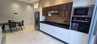 a kitchen with a counter and a table with a microwave at Villa Saadia in Douar Bellouk