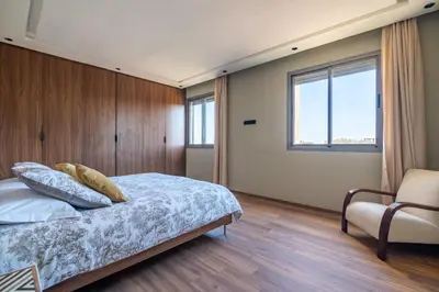 a bedroom with a bed and a chair and a window at Villa Saadia in Douar Bellouk
