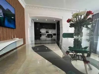 a living room with a vase with roses in it at appartement luxueux /confort , l’hivernage(Guéliz) au cœur de Marrakech in Marrakech