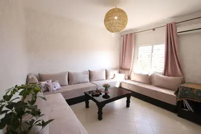 a living room with a couch and a table at appartement confort calme propre WIFI in Marrakech