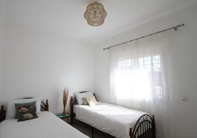 a bedroom with two beds and a window at appartement confort calme propre WIFI in Marrakech