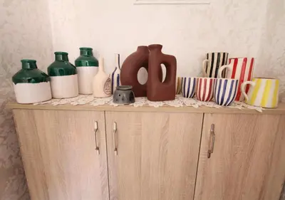 a shelf with vases and cups on top of a cabinet at appartement confort calme propre WIFI in Marrakech