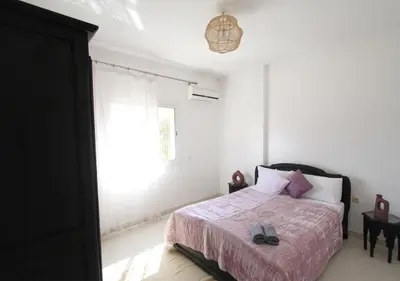 a bedroom with a bed with a pink blanket and a window at appartement confort calme propre WIFI in Marrakech