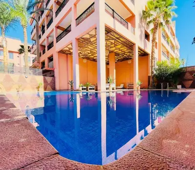a building with a swimming pool in front of a building at Appartement Résidence de standing Hivernage in Marrakech
