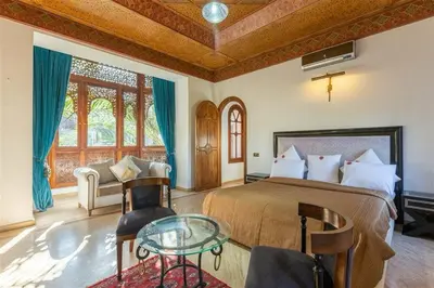 a bedroom with a bed and a glass table at Palais FARAH in Marrakech