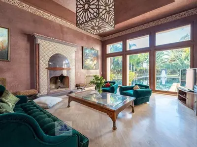 a living room with green furniture and a fireplace at Palais FARAH in Marrakech